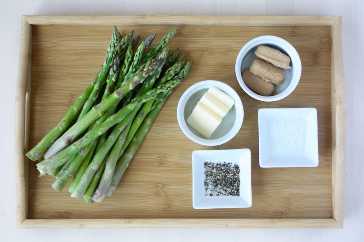 the ingredients for brown sugar asparagus on a wooden tray