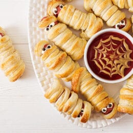 mummy hot dogs top view with spider web mustard and ketchup dip