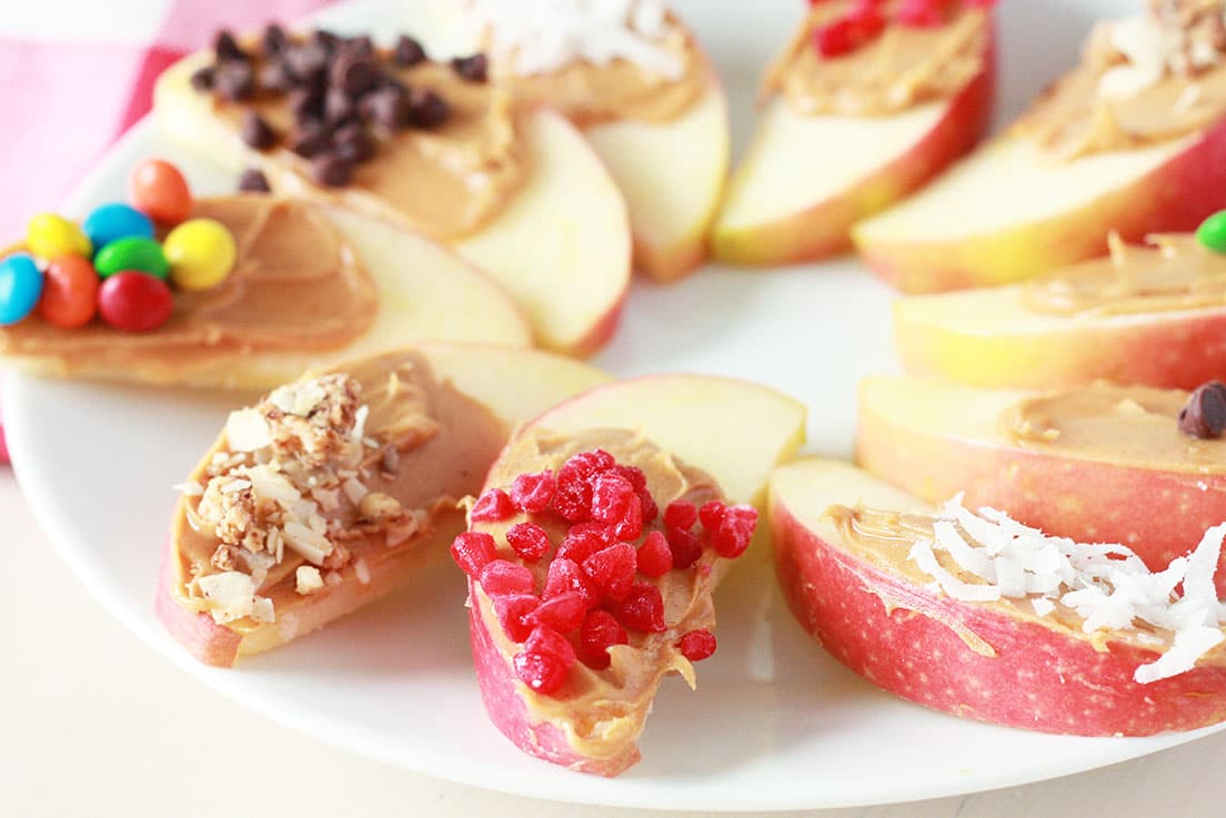 apple wedge snack with peanut butter and chopped nuts, frozen raspberries, coconut