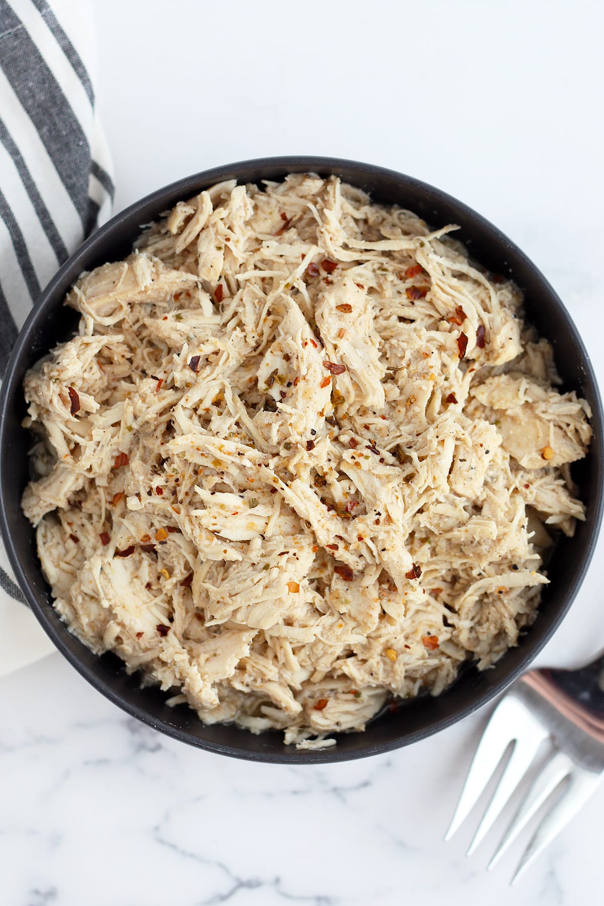 overhead view of cafe rio shredded chicken  recipe in a black bowl