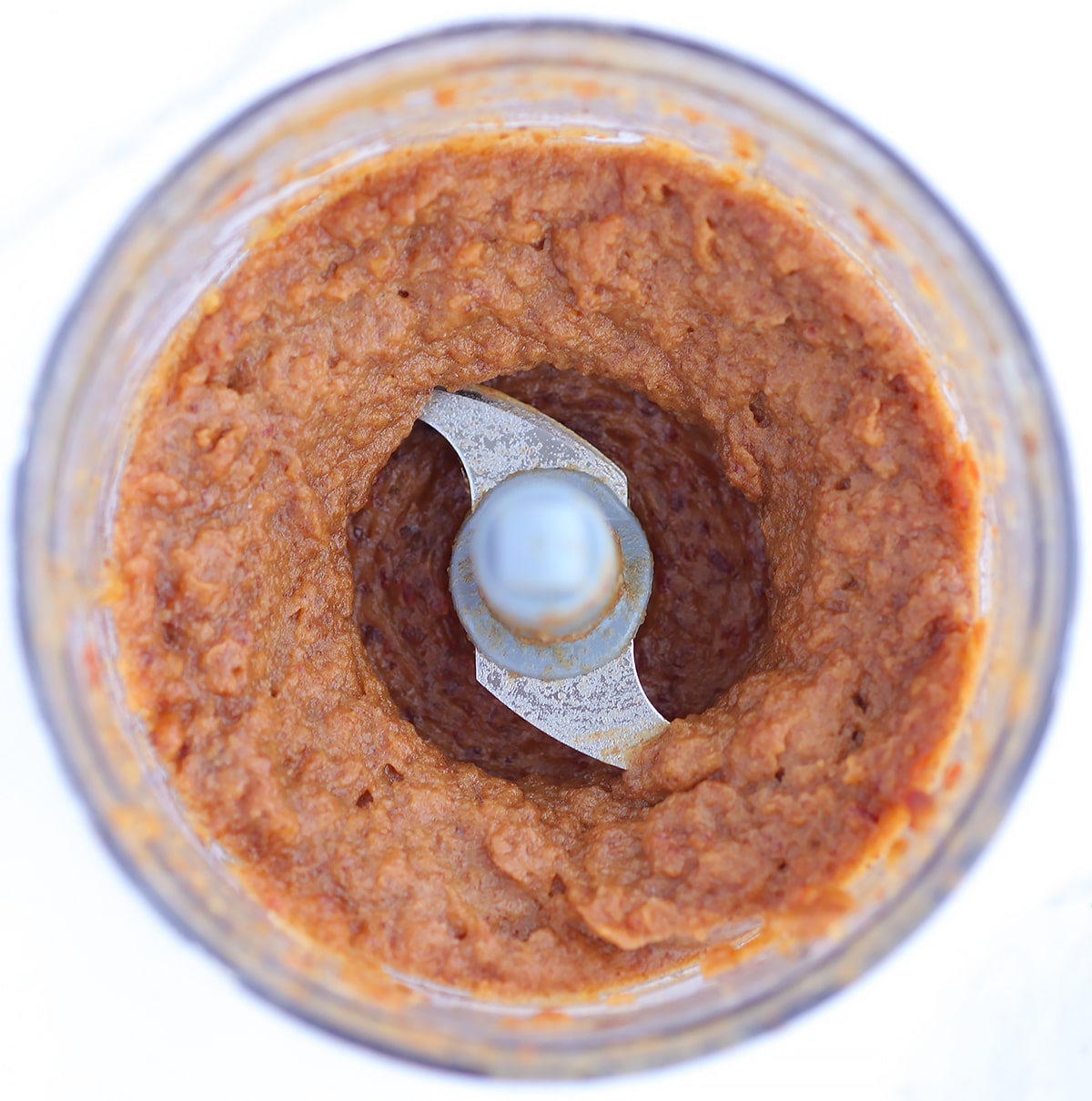 An overhead shot of pureed dates in a food processor. 