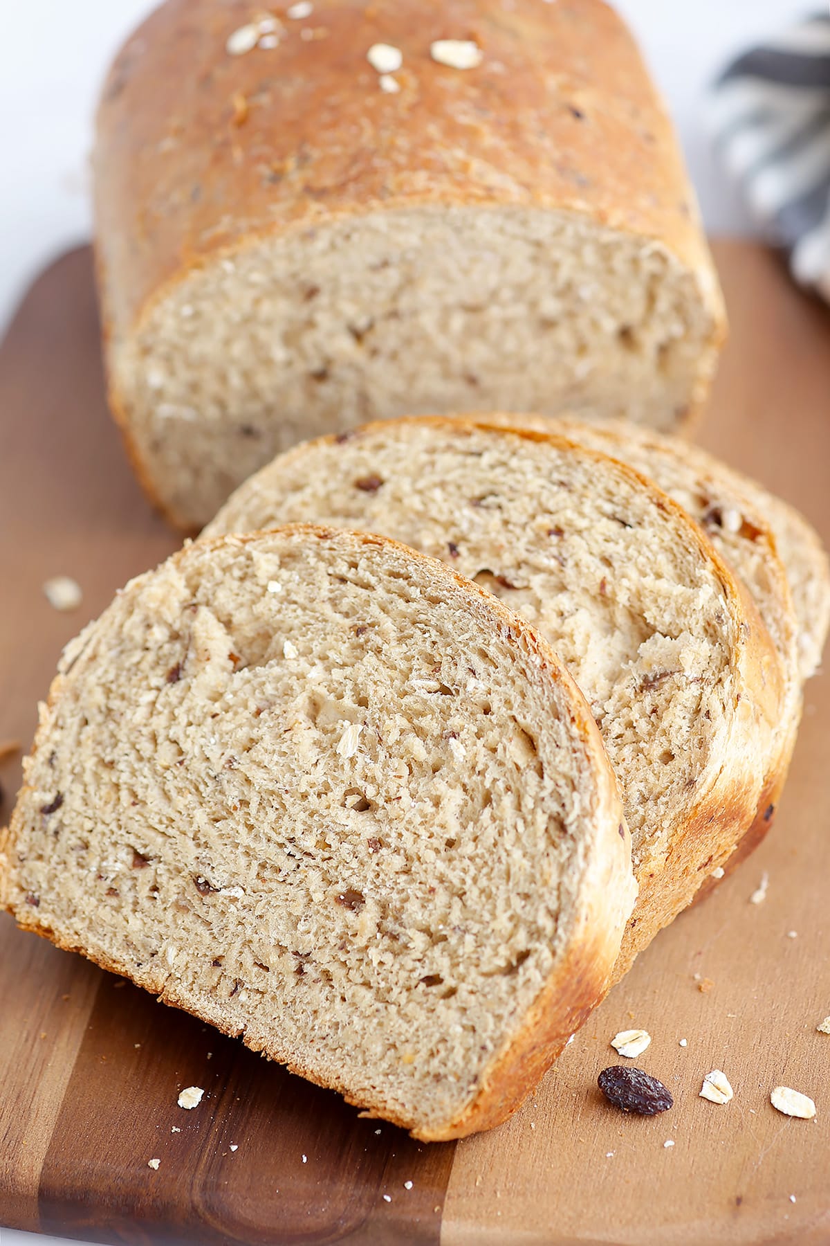 Fresh slices of homemade cinnamon raisin bread on a wooden board. 