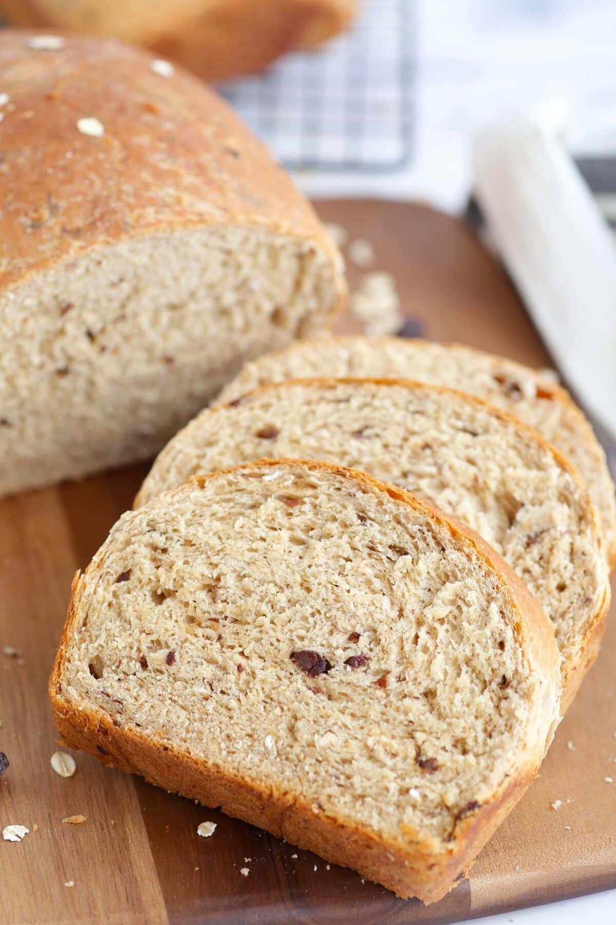 Slices of homemade cinnamon raisin bread on a wooden cutting board. 