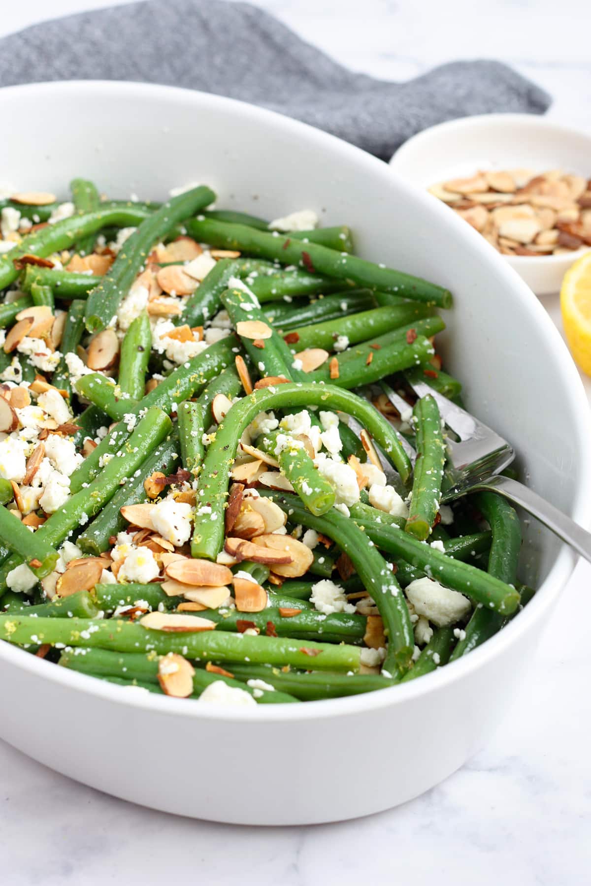 Fresh green bean tossed in a lemon vinaigrette in a serving dish. 