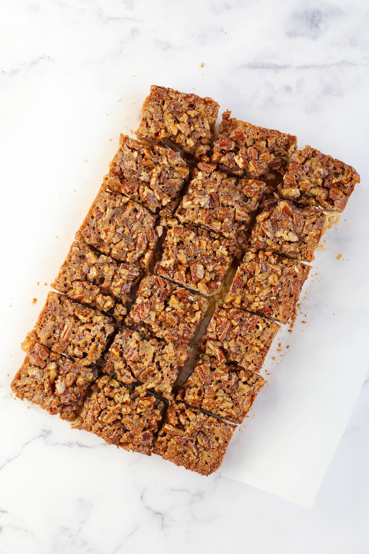 A slab of pecan pie bars, out of the pan and cut into squares. 